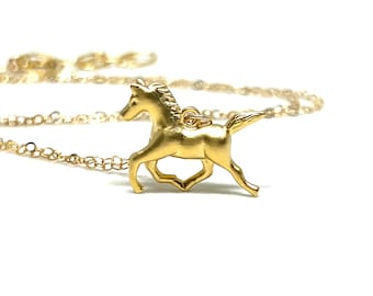 May include: A gold-toned necklace featuring a small, detailed horse pendant. The horse is depicted in a running pose.