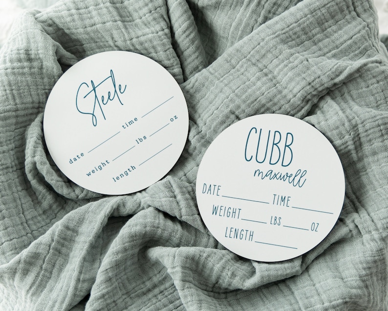 May include: Two white round wooden plaques with black text. The top plaque says "Steele" and has spaces for date, weight in lbs, length in inches, and time in oz. The bottom plaque says "CUBB maxwell" and has spaces for date, weight in lbs, length in inches, and time in oz.