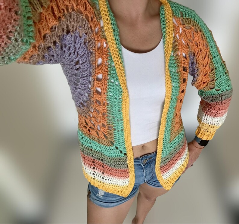 K&ouml;nnte beinhalten: Eine mehrfarbige H&auml;keljacke mit gelbem Besatz. Die Jacke ist vorne offen und hat eine lockere Passform.