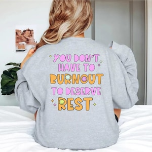 May include: Gray sweatshirt with the text "You don't have to burnout to deserve rest" in pink and orange with smiley faces.