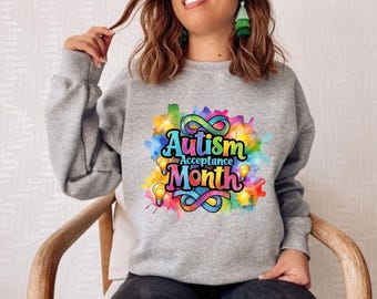 May include: Grey sweatshirt with a colourful graphic design that says "Autism Acceptance Month" with an infinity symbol and light bulbs.