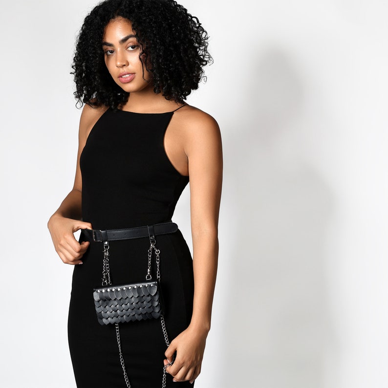 Crafted with precision, this handbag is suspended on a leather belt and adorned with two decorative chains, creating a sophisticated look that you can feel.