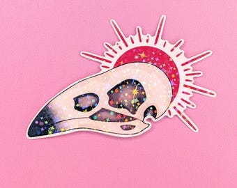 Pegatina de calavera de cuervo con sol rojo – Calcomanía de vinilo gótico de 7,6 cm con diseño celestial y acabado holográfico de estrella.