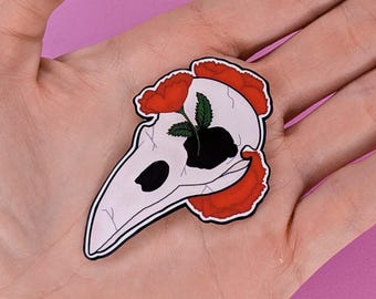 Pegatina floral de calavera de cuervo de 2 pulgadas con acabado brillante.