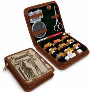 May include: A brown zippered sewing kit case featuring a medieval-style illustration on the cover. The interior contains a red pen, silver scissors, a needle case, a thimble, a white measuring tape, and multiple spools of colored thread.