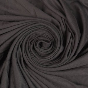 Puede incluir: Primer plano de una tela gris oscuro en espiral. La tela es suave y lisa, con un brillo sutil.