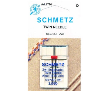 May include: A package of Schmetz twin needles, size 130/705 H ZWI, 3.0/90. The package is white with blue and red accents. The needles are in a clear plastic case.