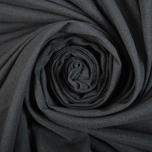 May include: Close-up of a black fabric swirled into a rose shape.