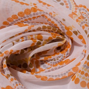 May include: White sheer fabric with a repeating pattern of orange and brown circles.