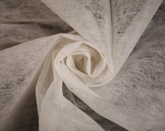 May include: A close-up of a white, soft, and delicate fabric, folded into a spiral shape, resembling a flower.