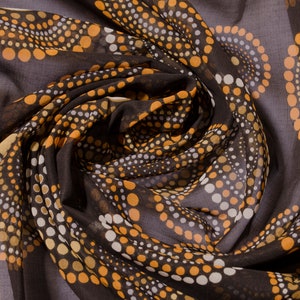 May include: Brown sheer fabric with a swirling pattern of white, tan, and orange polka dots.