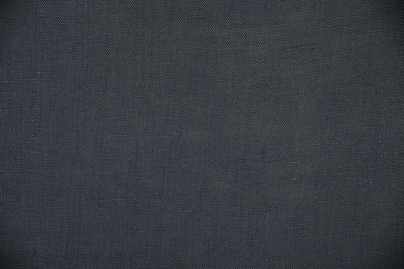 May include: A close-up of a dark gray fabric with a subtle woven texture.