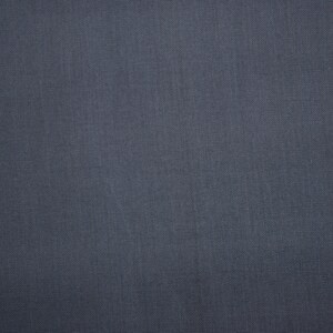 May include: A close-up of a dark gray fabric with a subtle texture. The fabric has a smooth, even surface with a slight sheen.