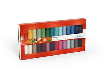 Op de afbeelding: Een rode doos met 24 spoelen Gutermann Seralon garen. De spoelen zijn gerangschikt in twee rijen van 12, met kleuren die variëren van wit tot donkerblauw. De doos heeft een transparant plastic venster dat de spoelen garen laat zien.