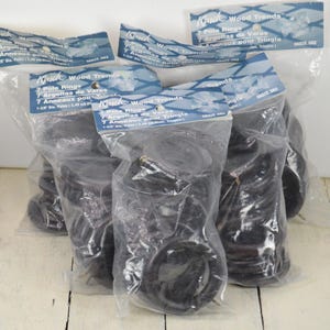 May include: Four packages of black plastic pole rings for crafts. Each package contains 7 rings and is labeled "Knick Wood Trends 7 Pole Rings 7 Argollas de Varas 7 Anneaux pour Tringle 1-3/8" Dia. Fits 1-1/8" Pole Tringle"