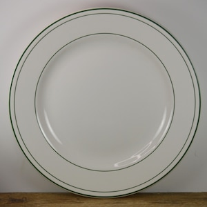 May include: White ceramic dinner plate with a green rim.