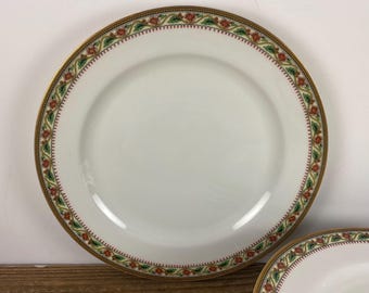 May include: White porcelain plates with a decorative border featuring red flowers, green leaves, and gold trim. The plates have a classic design, suitable for formal dining or special occasions.
