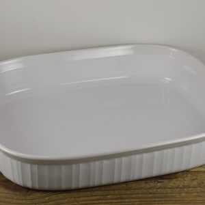 May include: White ceramic baking dish with a fluted rim. The dish is empty and ready to be used for baking.