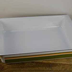 May include: White enamel baking dish with a green and orange striped border.