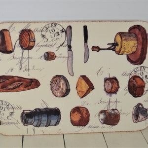 May include: A rectangular cutting board with a cream background and a vintage illustration of various cheeses, bread, and a cheese knife. The illustration includes the text "A GEN TO LIVR 1903".