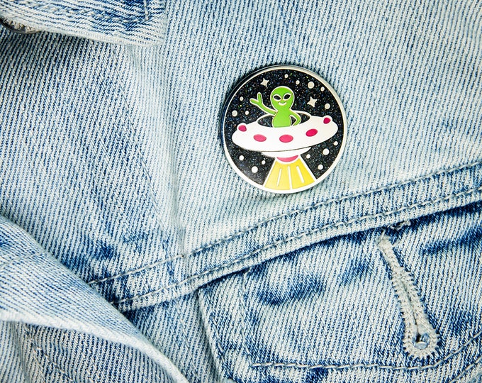 Greetings, Earthlings! Alien in a Flying Saucer enamel pin (glows in the dark!)