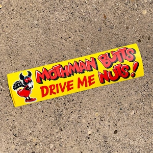 May include: A yellow and red bumper sticker with a cartoon mothman character and the text "Mothman Butts Drive Me Nuts!"
