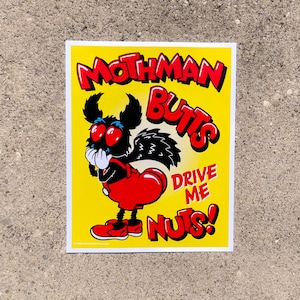 May include: A yellow sticker with a cartoon Mothman character. The Mothman is black with red eyes and a red heart-shaped butt. The text reads "Mothman Butts Drive Me Nuts!" in red and white lettering.