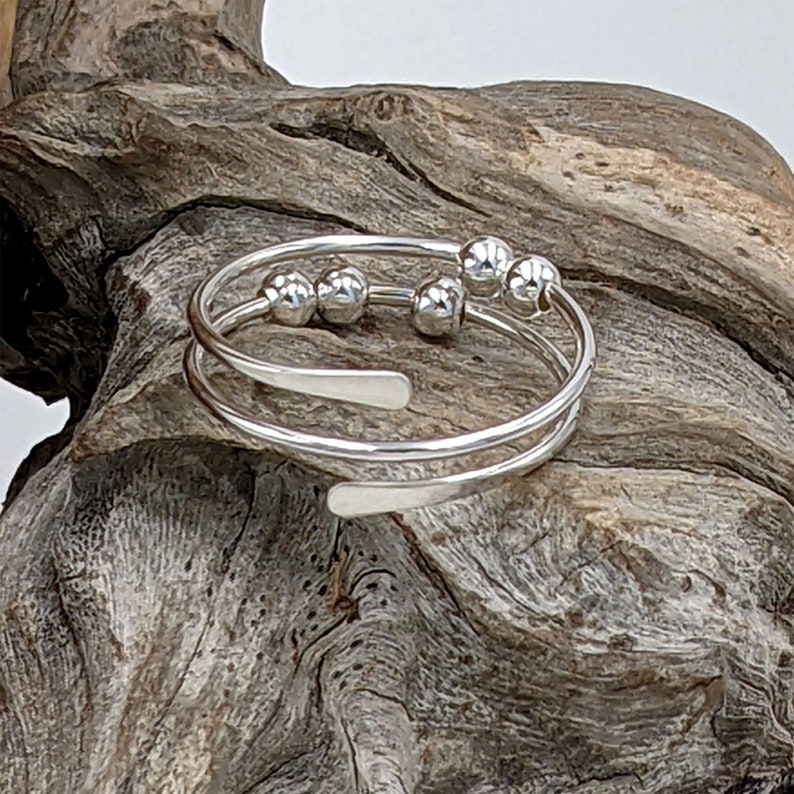 Spiral fidget ring with 5 round beads and hammered ends, in sterling silver