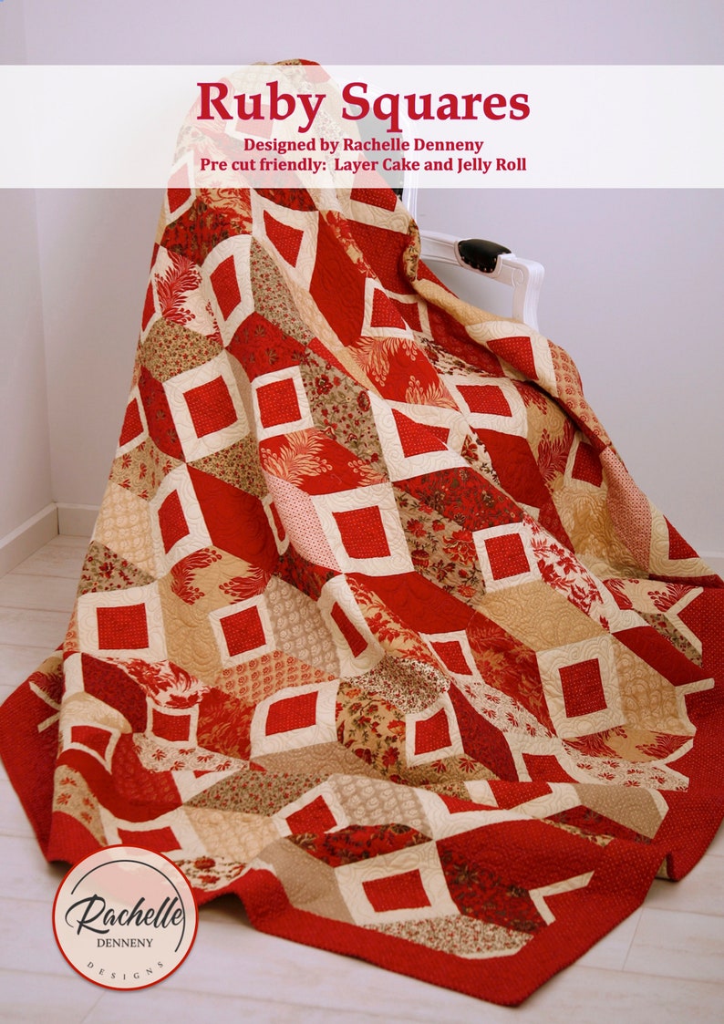 Op de afbeelding: Een rood en cr&egrave;mekleurig quilt met een geometrisch patroon van vierkanten. De quilt is over een witte stoel gegooid. De quilt heeft de titel "Ruby Squares" en is ontworpen door Rachelle Denneny. De quilt is geschikt voor voorgesneden stukken en kan worden gemaakt met een layer cake of jelly roll.