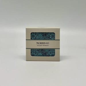 Może przedstawiać: Beżowe, prostokątne pudełko z napisem "MORRIS & Co POCKET MIRROR". Pudełko ma dwa prostokątne wycięcia, które odsłaniają turkusowy wzór kwiatowy. Projekt jest elegancki.