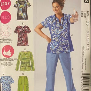 May include: McCall's sewing pattern M6473 for scrub tops and pants. The envelope displays illustrations of five garment variations, including floral and patterned short-sleeve tops and solid-colored pants, with size range B5 (8-10-12-14-16) clearly printed.