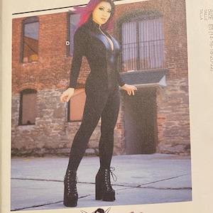 May include: McCall's sewing pattern M7217 featuring a long-sleeved black jumpsuit with a front zipper and a deep neckline. The pattern envelope displays a person wearing the jumpsuit with black platform lace-up boots and includes the Yaya Han logo.