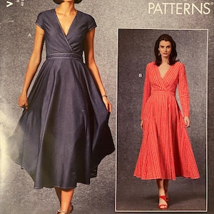 May include: Vogue Patterns sewing pattern featuring two dress designs. One dress is a dark blue denim-like fabric with a wrap-style bodice and a flared skirt. The other dress is a long-sleeved, coral-colored dress with a similar wrap design.