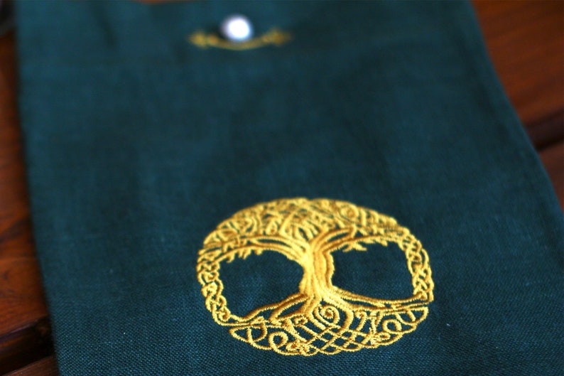 May include: A green fabric pouch with a gold embroidered Celtic knot tree of life design.