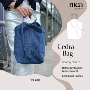 Könnte beinhalten: Eine dunkelblaue Jeanstasche mit zwei runden silbernen Griffen. Das Bild enthält den Text nica patterns, Cedra Bag, Sewing pattern, Detailed instructions & video tutorial, English and German sowie Two sizes und eine Strichzeichnung.