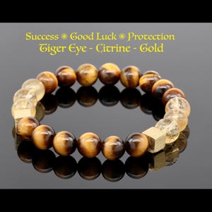 May include: A brown, gold, and clear beaded bracelet with the text "Success * Good Luck * Protection Tiger Eye - Citrine - Gold".