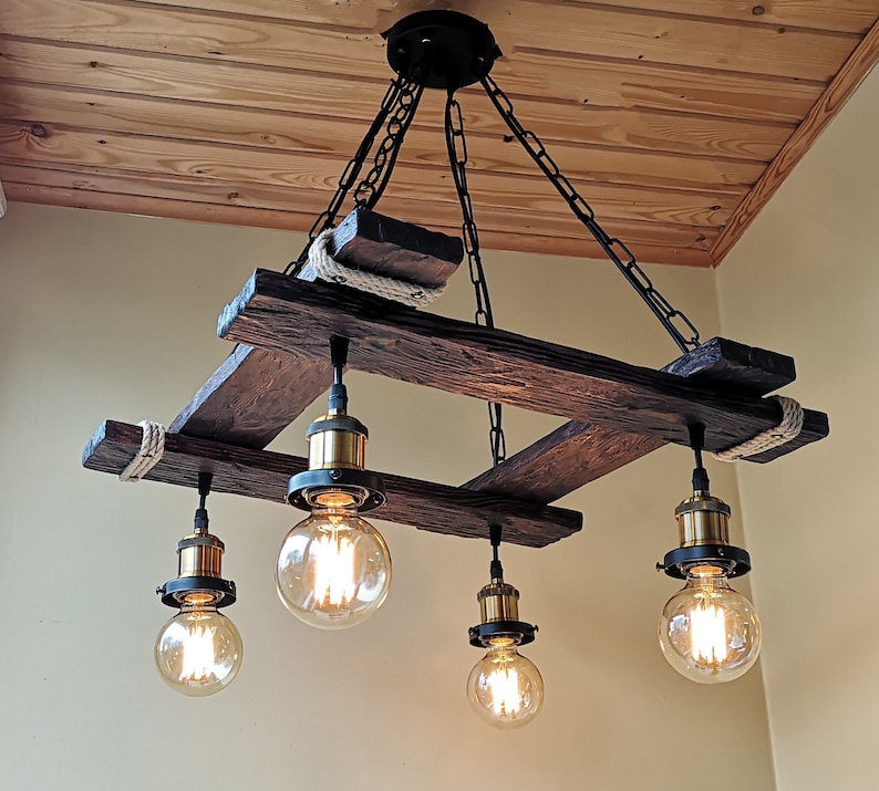 May include: A rustic wooden chandelier with five light bulbs. The chandelier is made of reclaimed wood and has a natural finish. The light bulbs are Edison-style and have a warm white glow.