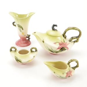 May include: A vintage tea set with a green and pink floral design. The set includes a teapot, creamer, sugar bowl, and a vase.