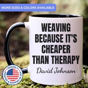 May include: A white ceramic mug with a black interior and a black handle. The front of the mug features the black text "WEAVING BECAUSE IT'S CHEAPER THAN THERAPY" followed by the name "David Johnson" in a cursive script font.