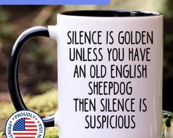 May include: A white ceramic mug with a black interior and handle, featuring the black printed text: SILENCE IS GOLDEN UNLESS YOU HAVE AN OLD ENGLISH SHEEPDOG THEN SILENCE IS SUSPICIOUS. The mug includes a circular badge with the American flag.