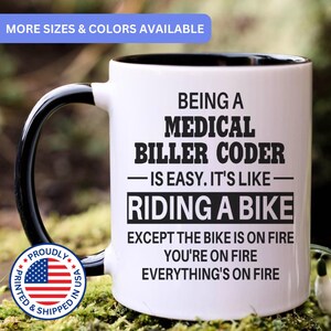 May include: A white ceramic mug with a black interior and handle, featuring black text that reads: BEING A MEDICAL BILLER CODER IS EASY. IT'S LIKE RIDING A BIKE EXCEPT THE BIKE IS ON FIRE YOU'RE ON FIRE EVERYTHING'S ON FIRE.