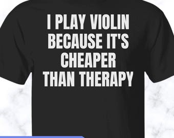 May include: A black short-sleeved t-shirt featuring white text that reads, I PLAY VIOLIN BECAUSE IT'S CHEAPER THAN THERAPY. The shirt has a crew neckline and a standard fit, with the bold white lettering centered prominently on the front chest area.