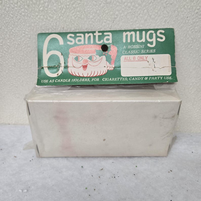 May include: A package of six Santa mugs, a Rossini Classic Series product. The green header features a Santa Claus illustration and text that reads "Use as candle holders, for cigarettes, candy & party use."