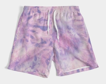 May include: Tie-dye shorts in shades of purple, pink, and white. The shorts have an elastic waistband with a white drawstring. The fabric has a swirling pattern, creating a unique and colorful design. Casual wear.