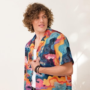 May include: Short-sleeved button-down shirt with a vibrant, abstract design. The shirt features a colorful pattern with swirls of blue, orange, yellow, and pink. The shirt is worn over a white undershirt.
