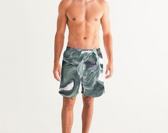 May include: A pair of men's swim trunks with a green and white abstract pattern. The pattern features swirling lines and shapes.