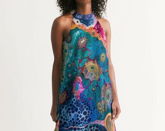 May include: A halter-style dress with a vibrant blue, pink, and yellow abstract print. The dress has a loose fit and a flowing skirt.