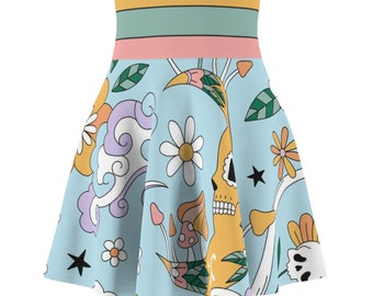 May include: A light blue skirt with a colorful print featuring a skull, flowers, mushrooms, and stars. The skirt has a yellow, green, and pink waistband.