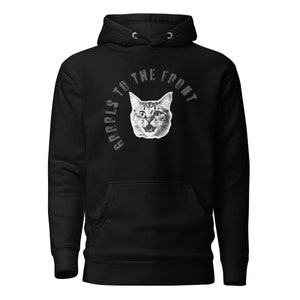 Puede incluir: Sudadera con capucha negra con un gráfico blanco de un gato con el texto "GERRLS TO THE FRONT" en un diseño circular.