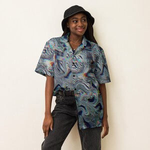May include: A short-sleeved button-down shirt featuring a multi-colored wavy, psychedelic liquid marble pattern in shades of blue, gray, and iridescent highlights. The shirt has a classic collar, a front button closure, and a loose, relaxed fit.